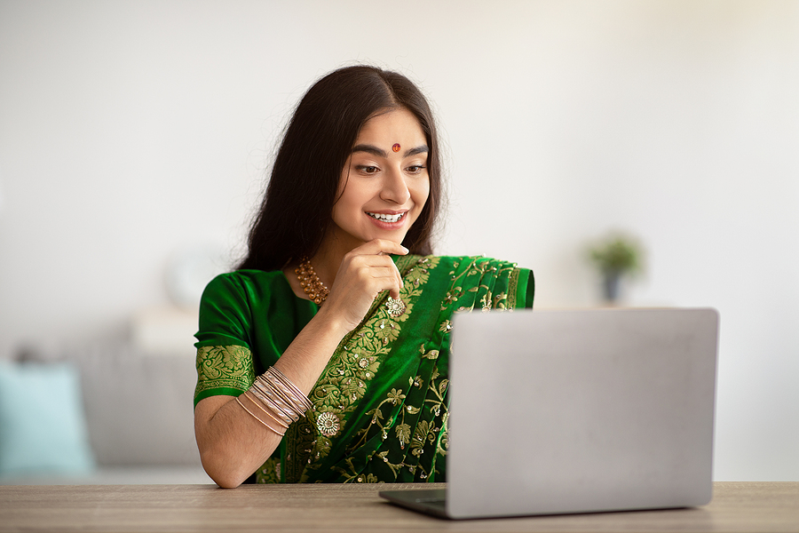 A young Indian female doing online learning at her laptop as part of her level 3 childcare apprenticeship